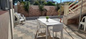 a white table and chairs on a patio at Villa Rifla Attico in Lizzano
