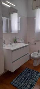 bagno con grande lavandino bianco e servizi igienici di Villa Rifla Attico a Lizzano