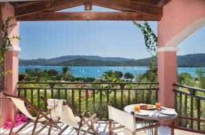 a table and chairs on a balcony with a view of the water at Resort Cala Di Falco in Cannigione