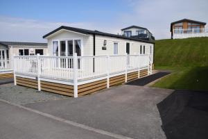 a white mobile home with a white fence at 32 Bayview Oceans Edge in Morecambe