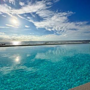 una gran piscina de agua junto a la playa en TANA Beach Villas, en Lian