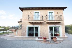 a large brick house with two balconies on it at Depandace Lavanda in Castignano