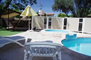 a patio with a pool and a chair and a table at Terrabella Apart in Mendoza