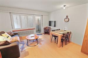Chaleureux studio plein centre في لوكرباد: غرفة معيشة مع طاولة وغرفة طعام