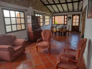 sala de estar con sofá, sillas y mesa en El Rincon de Quevedo, en Sáchica