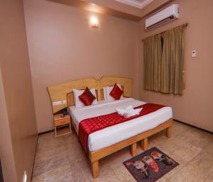 蒂魯普的住宿－Hotel Vinayaga Excellency Tiruppur，一间卧室配有一张带红色毯子的大床
