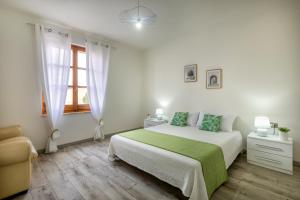 Un dormitorio blanco con una cama y una ventana. en Casa Belvedere, en Codrongianos