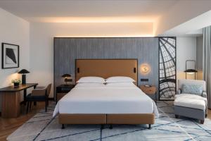 a bedroom with a large bed and a desk at Sheraton Mall of the Emirates Hotel, Dubai in Dubai