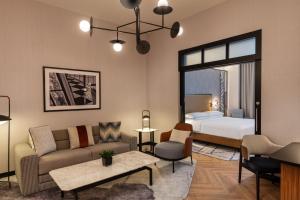 a living room with a room with a bed and a couch at Sheraton Mall of the Emirates Hotel, Dubai in Dubai