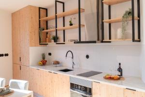 kuchnia z drewnianymi szafkami i zlewem w obiekcie Luxurious Bright Flats - Ace Location w Porto