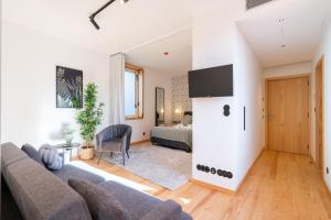 a living room with a couch and a bedroom at Luxurious Bright Flats - Ace Location in Porto