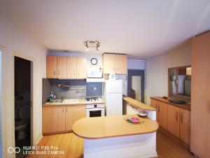 a kitchen with a table and a white refrigerator at Chez Maïté in Vals-les-Bains +3 photos