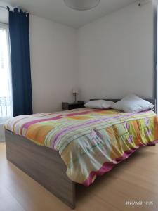 a bedroom with a bed with a colorful blanket on it at Chez Maïté in Vals-les-Bains