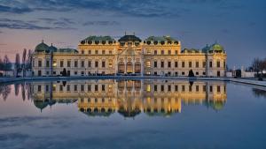 a large building with its reflection in the water at Central Station Loft - Amazing View in City Center - jupihome in Vienna