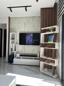 ein Wohnzimmer mit einem TV an der Wand in der Unterkunft Coin Confort 2 chambres de luxe avec piscine in Tétouan