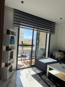 ein Wohnzimmer mit einem Sofa und einem großen Fenster in der Unterkunft Coin Confort 2 chambres de luxe avec piscine in Tétouan