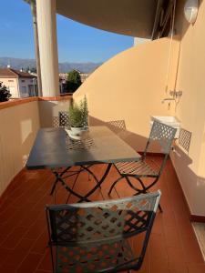 stół i krzesła na balkonie z doniczką w obiekcie Adua Flat - perfect place for visiting Tuscany w mieście Pistoia