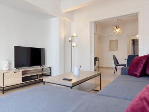 a living room with a couch and a tv at Marnis Spacious 105 sqm apt in Athens in Athens