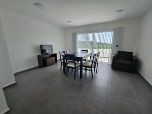 Un comedor con mesa y sillas y un televisor. en CountryHome Tierra Alta, en Villa San Nicolás