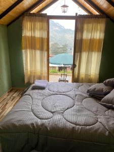 Cama grande en habitación con ventana grande en Hospedaje - Cabañas villa rosita, en Monguí