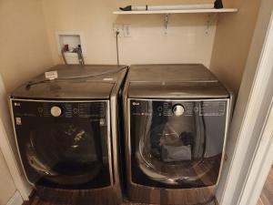 two washing machines are sitting in a closet at Stylish 3 bed, minutes to NYC! in Jersey City