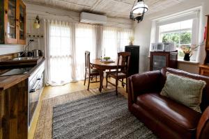 Cape Bridgewater的住宿－Devlin's Cottage，客厅配有沙发和餐桌,厨房配有桌子