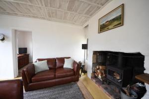 un soggiorno con divano e camino di Devlin's Cottage a Cape Bridgewater Altre 7 foto