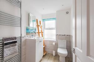 Samphire Cottage by Bloom Stays في برودستيرز: حمام ابيض مع مرحاض ومغسلة