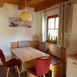 ein Esszimmer mit einem Holztisch und roten Stühlen in der Unterkunft Ferienhaus MARIA im Waldferiendorf in Regen