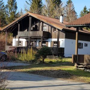 ein großes Haus mit einer Veranda und einem weißen in der Unterkunft Ferienhaus MARIA im Waldferiendorf in Regen