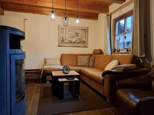 ein Wohnzimmer mit einem Sofa und einem Kamin in der Unterkunft Ferienhaus MARIA im Waldferiendorf in Regen