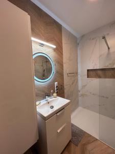 een badkamer met een wastafel en een douche bij BoleslaviaApartments - Apartament Merci 2, parking free in Bolesławiec