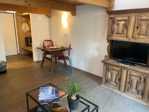 un soggiorno con grande TV e tavolo di Hotel des Alpes a Flims