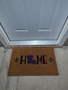 un tapis de bienvenue devant une porte avec le mot aide dans l'établissement The Comfort Zone, à Bâton-Rouge