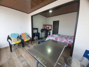 a bedroom with a bed and a table and chairs at Apto-baño privado y área de trabajo para ti solo in Acacías
