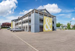 a large building with a sign on the front of it at B&B HOTEL STRASBOURG Nord Industrie in Vendenheim