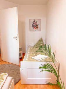 um pequeno quarto com uma cama e uma planta em 2 Zimmer City Apartment mit Terrasse und Tiefgaragenstellplatz in Zentrum von Leipzig em Leipzig