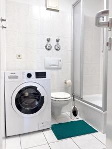 uma casa de banho com uma máquina de lavar roupa e um WC. em 2 Zimmer City Apartment mit Terrasse und Tiefgaragenstellplatz in Zentrum von Leipzig em Leipzig