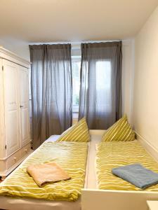 Un dormitorio con dos camas frente a una ventana. en 2 Zimmer City Apartment mit Terrasse und Tiefgaragenstellplatz in Zentrum von Leipzig, en Leipzig
