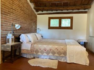 a bedroom with a bed and a brick wall at Habitación suite en Masía Can Robira in Els Hostalets