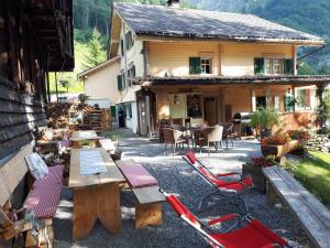 a group of chairs and tables in front of a building at Berggasthaus Obbort in Linthal