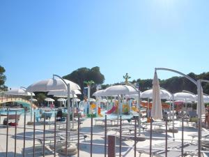 a pool with chairs and umbrellas at a water park at Tra i Pini in Lignano Sabbiadoro