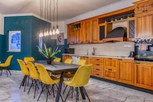 a kitchen with a wooden table and yellow chairs at Stunning, Seafront 3BR home in the heart of Sliema by 360 Estates in Sliema