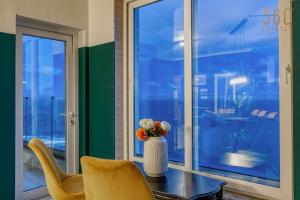 un jarrón con flores en una mesa junto a una ventana en Stunning, Seafront 3BR home in the heart of Sliema by 360 Estates, en Sliema