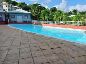 ein Swimmingpool in einem Resort mit blauem Wasser in der Unterkunft Chez Valérie et Pascal in La Trinité
