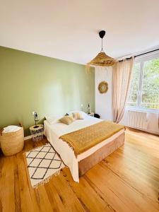 een slaapkamer met een groot bed en een groot raam bij Appartement cosy - centre-ville in Lorient