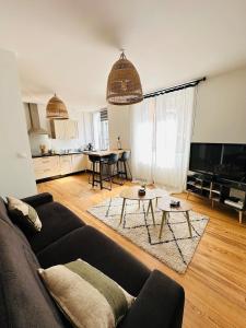 een woonkamer met een bank en een tafel bij Appartement cosy - centre-ville in Lorient