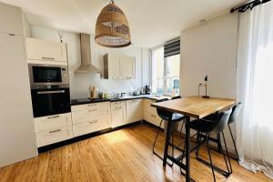 een keuken met een houten tafel en een houten vloer bij Appartement cosy - centre-ville in Lorient