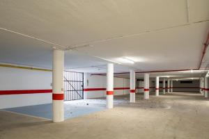 an empty parking garage with white and red columns at Hotel Alda Malvasía in Haro