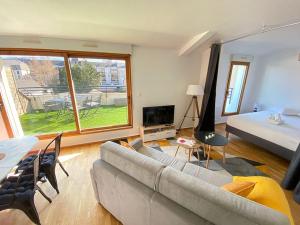 uma sala de estar com um sofá e uma cama em Grand studio, belle terrasse avec vue em Nantes